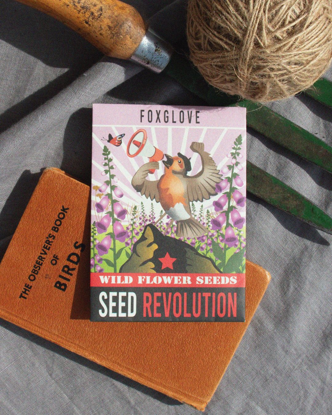 Seed packet for foxglove wildflower seeds on a rustic gardening background. Showcasing Seed Revolution's Foxglove, Digitalis purpurea, Foxgloves, Digitalis Foxglove, flower foxglove, foxglove flowers, british wild flower seeds, british wildflower seeds, uk wildflower seeds.